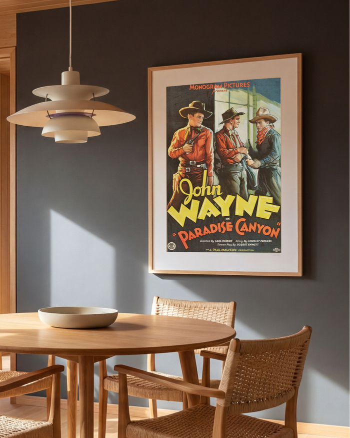 Framed John Wayne Paradise Canyon poster in a dining room